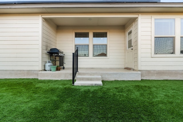 entrance to property with a lawn