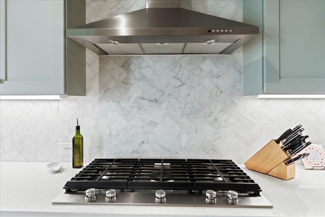 kitchen featuring wall chimney range hood, decorative backsplash, and stainless steel gas cooktop