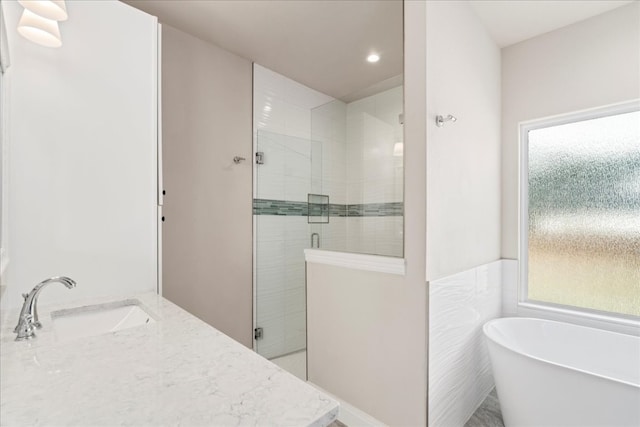 bathroom with plus walk in shower, sink, and tile walls