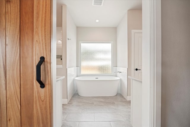 bathroom featuring tile walls and a bathing tub