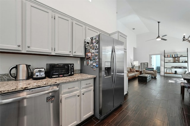 kitchen with white cabinets, high vaulted ceiling, and appliances with stainless steel finishes