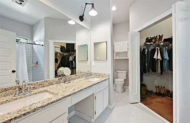 bathroom with tile patterned flooring, vanity, toilet, and walk in shower