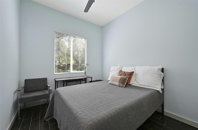 bedroom featuring dark hardwood / wood-style floors, ceiling fan, and lofted ceiling