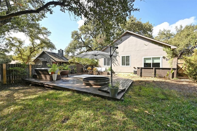 view of yard featuring a deck and an outdoor fire pit