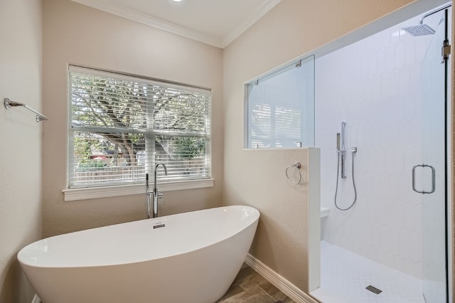 bathroom with ornamental molding and shower with separate bathtub