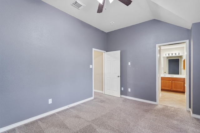 unfurnished bedroom with vaulted ceiling, light colored carpet, ceiling fan, and ensuite bathroom