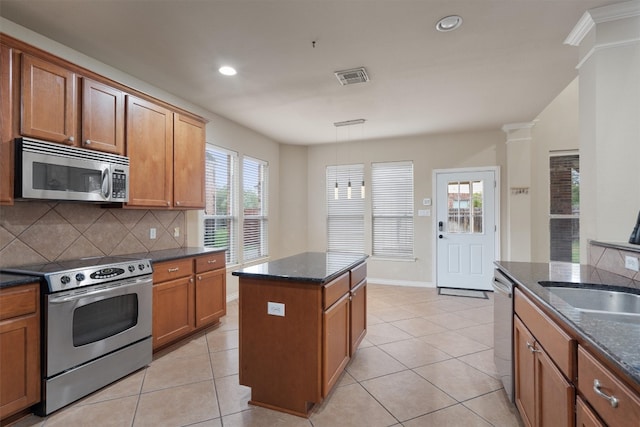 kitchen with dark stone countertops, decorative backsplash, stainless steel appliances, and light tile patterned flooring