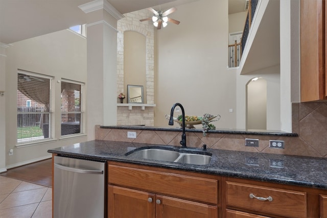 kitchen with tile patterned flooring, sink, stainless steel dishwasher, and dark stone counters