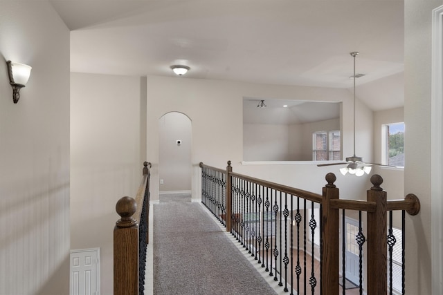 hall featuring vaulted ceiling and carpet