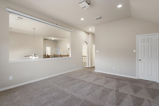 carpeted empty room featuring ceiling fan and vaulted ceiling