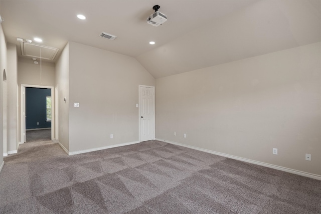 empty room featuring vaulted ceiling and carpet