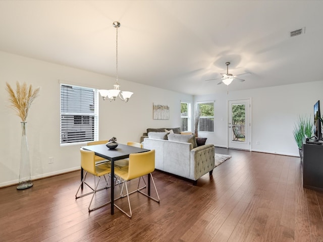 living room featuring dark wood-type flooring and ceiling fan with notable chandelier