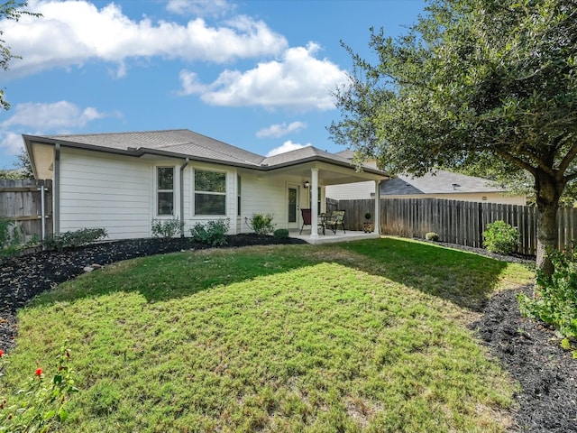 back of property featuring a yard and a patio