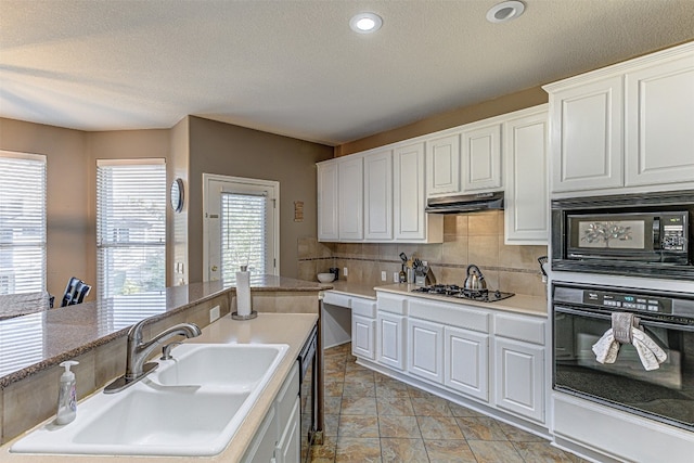 kitchen featuring white cabinetry, a textured ceiling, black appliances, and sink