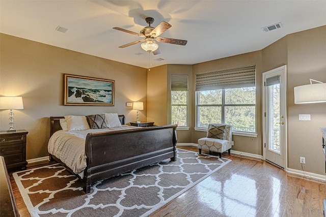 bedroom featuring visible vents, wood-type flooring, baseboards, and ceiling fan