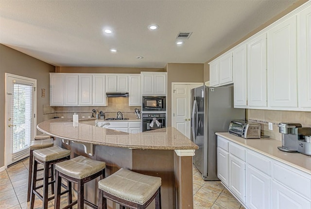 kitchen featuring under cabinet range hood, visible vents, white cabinetry, and black appliances