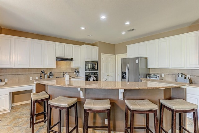 kitchen with decorative backsplash, black appliances, white cabinetry, and under cabinet range hood