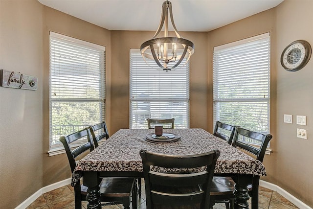 dining area with a chandelier, plenty of natural light, and baseboards