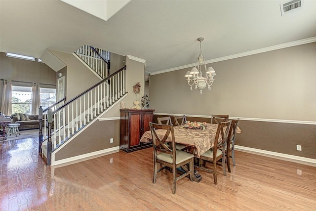 dining area featuring visible vents, baseboards, stairway, ornamental molding, and wood finished floors