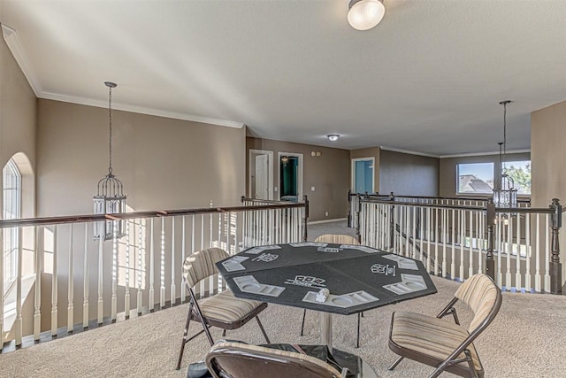 interior space with a chandelier, baseboards, carpet, and ornamental molding