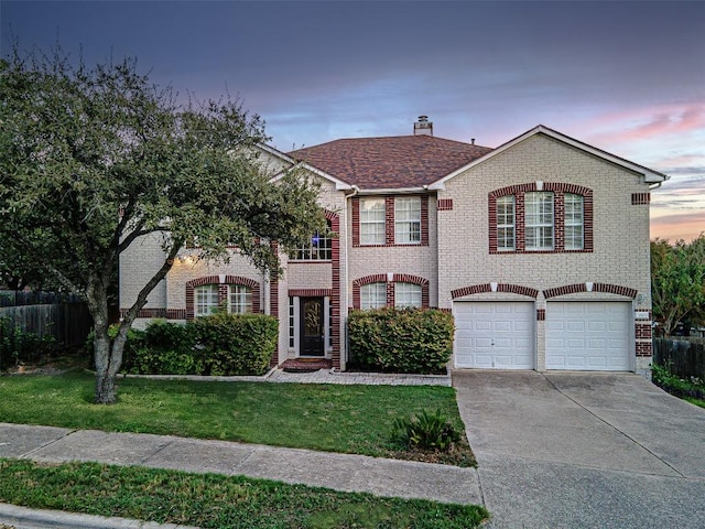 view of front of house with a front lawn, fence, concrete driveway, an attached garage, and brick siding