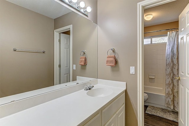 full bathroom with shower / tub combo with curtain, toilet, a textured ceiling, wood finished floors, and vanity