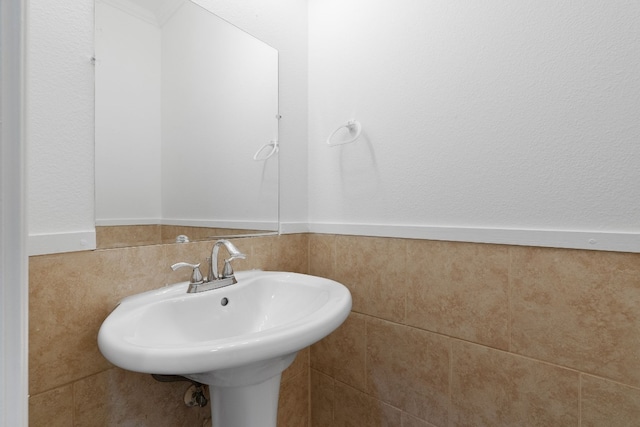 bathroom with tile walls and sink