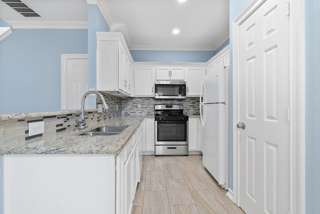 kitchen featuring light stone countertops, sink, stainless steel appliances, white cabinets, and ornamental molding