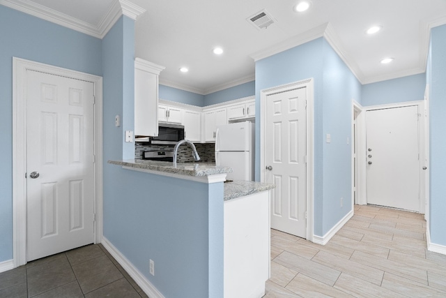 kitchen featuring white cabinetry, crown molding, appliances with stainless steel finishes, and kitchen peninsula