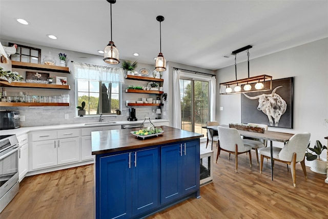 kitchen with white cabinets, decorative light fixtures, blue cabinets, and sink