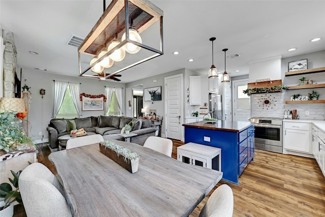 dining room with ceiling fan and light hardwood / wood-style floors