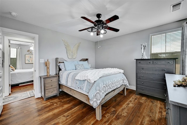 bedroom with dark hardwood / wood-style floors and ceiling fan