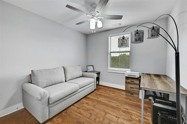 living room featuring ceiling fan and hardwood / wood-style flooring