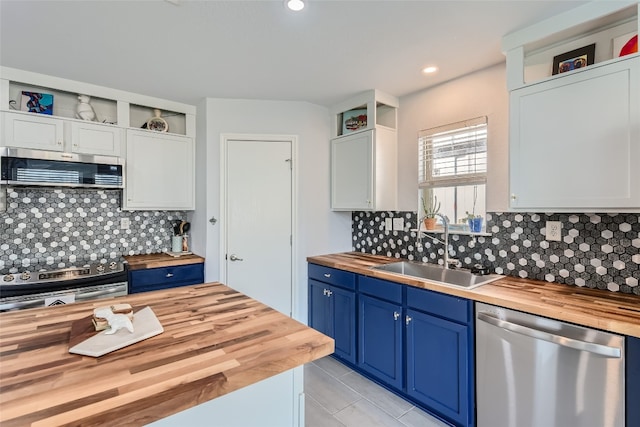 kitchen featuring butcher block counters, white cabinetry, sink, stainless steel appliances, and exhaust hood