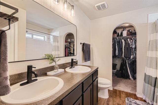 bathroom with walk in shower, toilet, vanity, and hardwood / wood-style flooring