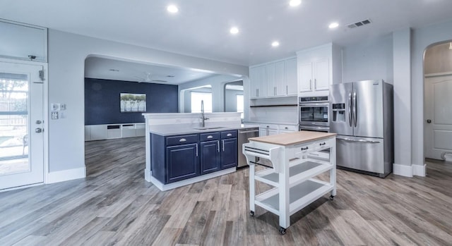 kitchen with ceiling fan, sink, appliances with stainless steel finishes, white cabinets, and light wood-type flooring