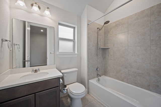 full bathroom featuring lofted ceiling, toilet, tile patterned flooring, tiled shower / bath, and vanity