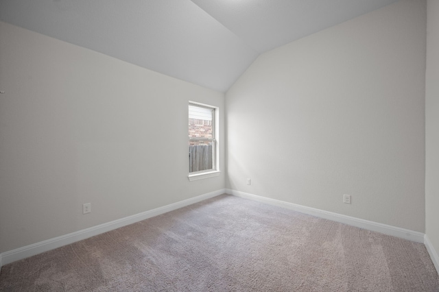 unfurnished room with lofted ceiling and carpet flooring