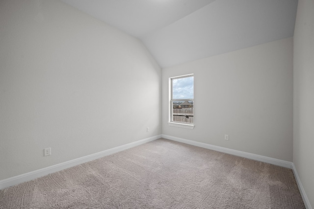 empty room featuring vaulted ceiling and carpet floors