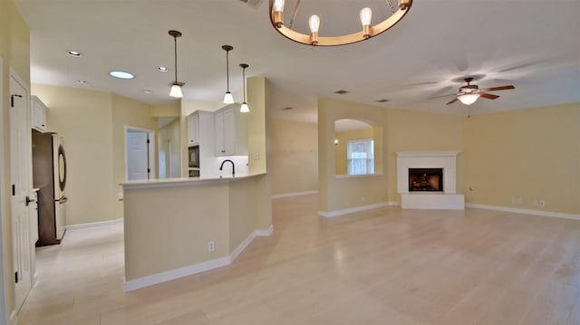 kitchen with ceiling fan, stainless steel appliances, light hardwood / wood-style floors, decorative light fixtures, and white cabinets