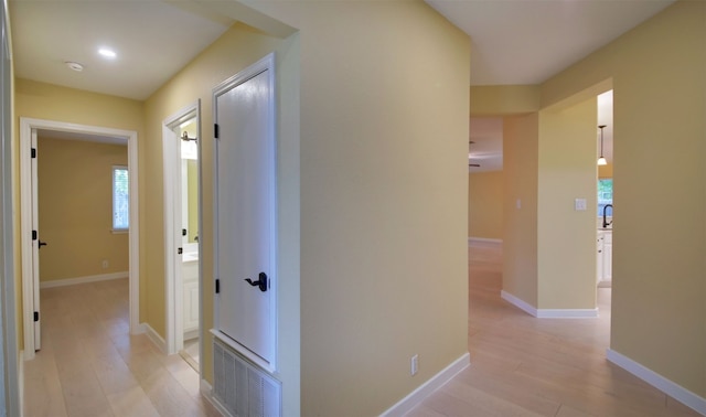 corridor featuring light hardwood / wood-style floors and sink