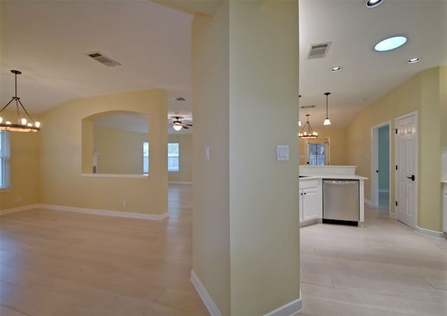 hall with light wood-type flooring, vaulted ceiling, and an inviting chandelier