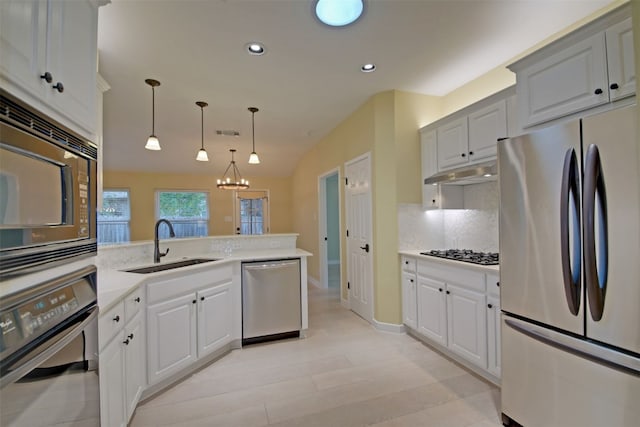 kitchen featuring hanging light fixtures, an inviting chandelier, tasteful backsplash, light stone counters, and appliances with stainless steel finishes