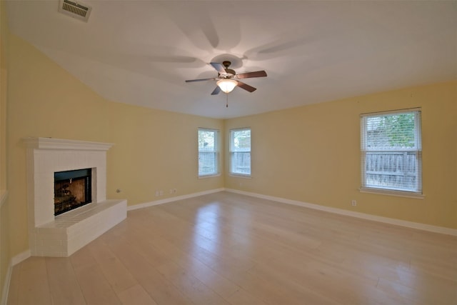 unfurnished living room featuring a brick fireplace, ceiling fan, and light hardwood / wood-style flooring