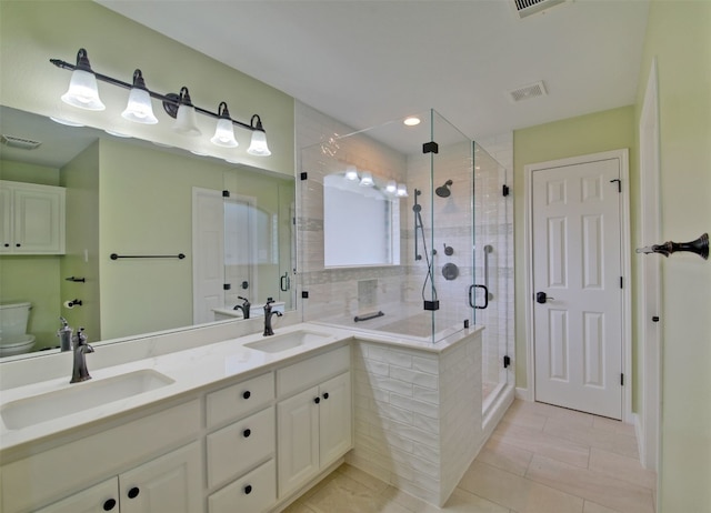 bathroom with tile patterned flooring, a shower with door, vanity, and toilet