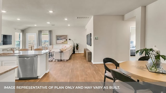 kitchen featuring stainless steel dishwasher, sink, white cabinets, and light wood-type flooring