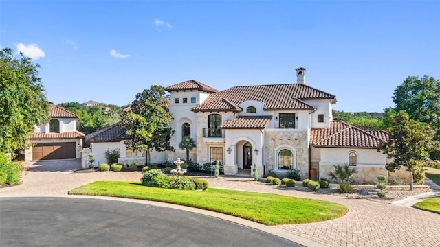 mediterranean / spanish house with a front yard and a garage