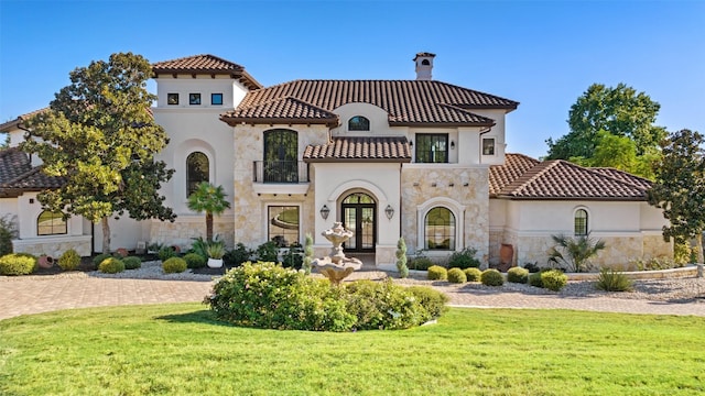 mediterranean / spanish home with french doors and a front lawn