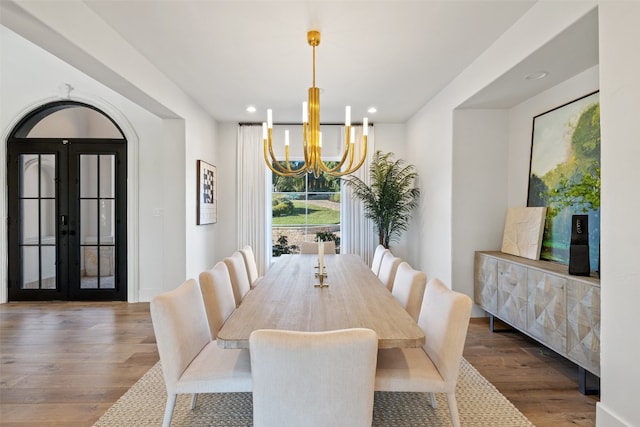 dining room with a notable chandelier, french doors, and wood-type flooring