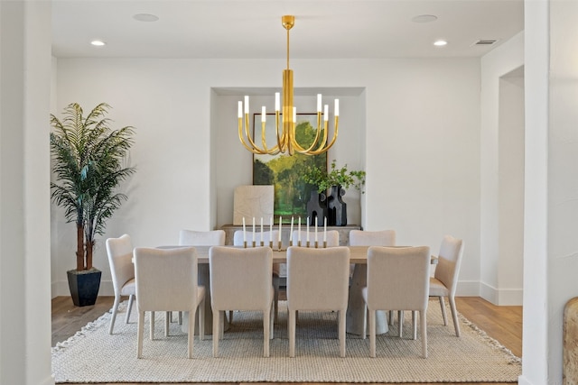 dining space featuring light hardwood / wood-style flooring and a notable chandelier